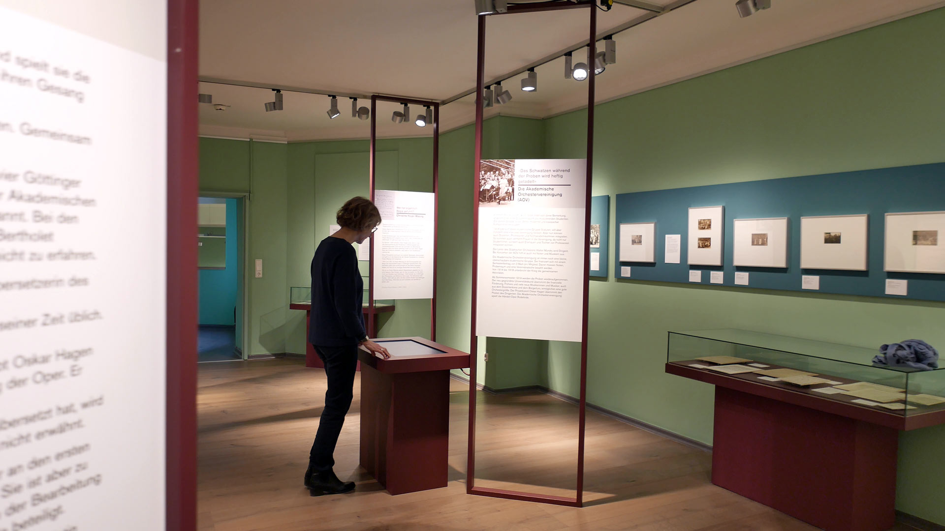 Eine Frau schaut sich die Hörstation einer Museumsausstellung an.